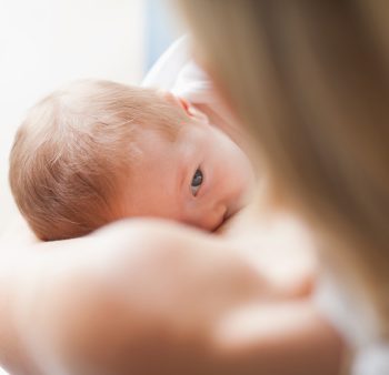 Above view of newborn getting breastfed